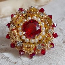 Bague L’Oiseau des Iles Rouge Doré avec un cabochon Rouge sur une estampe dorée ornée de cristaux : toupies et chatons. Les perles rondes nacrées Ivoire et Rouge complète cette bague réglable